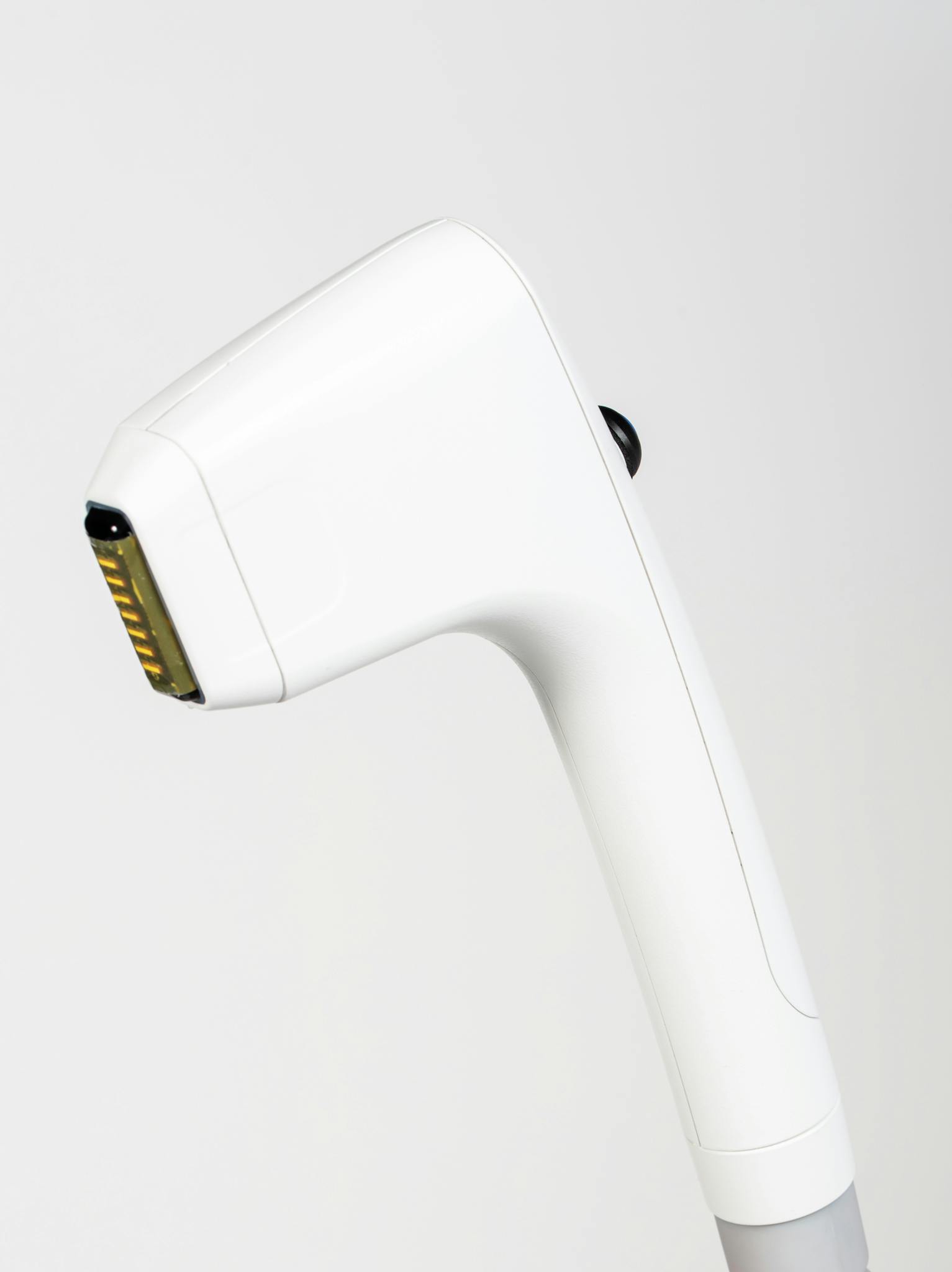 Close-up of a sleek handheld ultrasound machine used for wrinkle reduction in a studio setting.